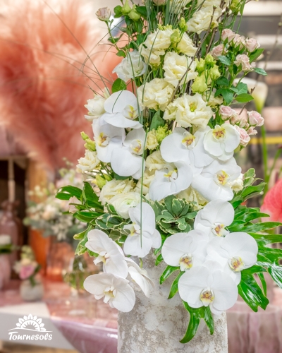 Composition florale avec orchidées blanches et roses, présentée par Tournesols au salon du mariage de Charleroi 2026.